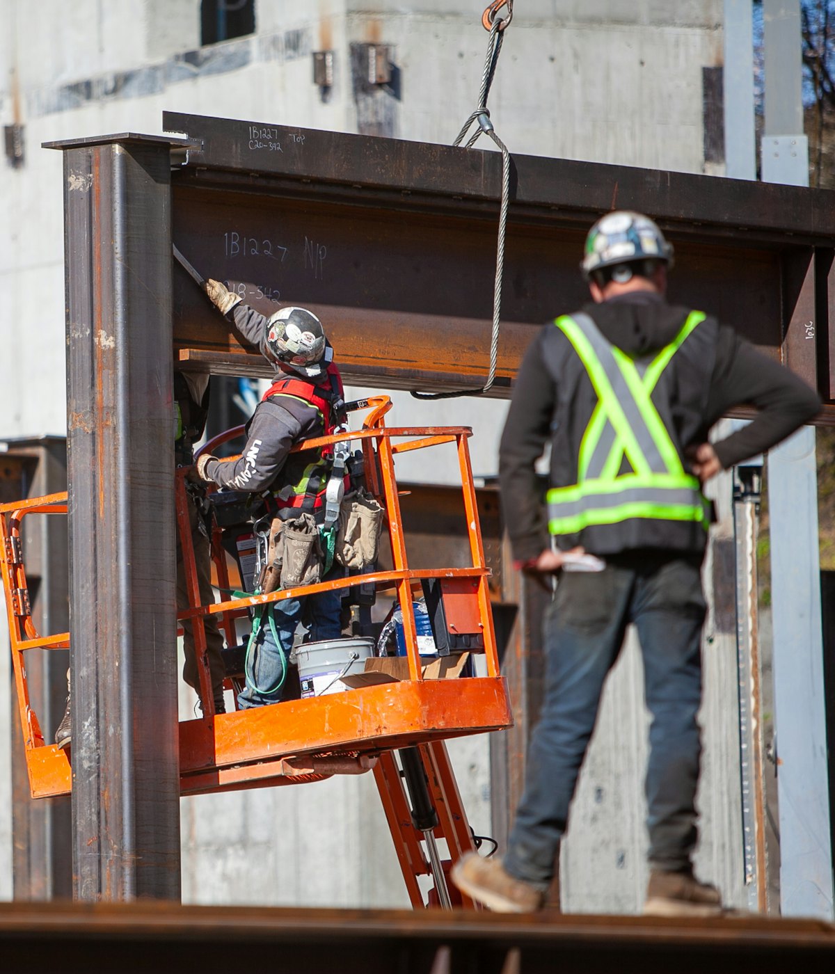 Steel erectors installing a structural beam on site